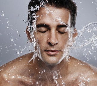 Man splashing water on his face to stay hydrated